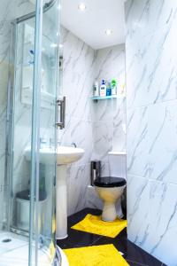 a bathroom with a glass shower and a toilet at Rare London 6bedroom House in South Norwood