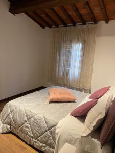 Schlafzimmer mit einem großen Bett und einem Fenster in der Unterkunft La finestra sulla torre in Castiglion Fiorentino