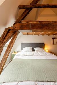 een wit bed in een kamer met houten balken bij Little Antwerp holiday home in Antwerpen