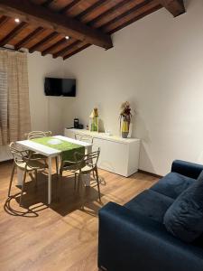ein Wohnzimmer mit einem Tisch und einem blauen Sofa in der Unterkunft La finestra sulla torre in Castiglion Fiorentino