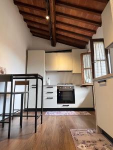 a kitchen with white appliances and a wooden ceiling at La finestra sulla torre in Castiglion Fiorentino