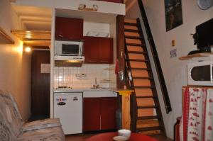 uma pequena cozinha com uma escada que leva a um quarto em Olympe - 104 - Studio - 4 pers em Les Deux Alpes