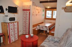 a room with a living room with a table and a tv at Olympe - 104 - Studio - 4 pers in Les Deux Alpes