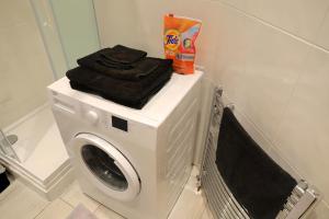 a washing machine with a pile of towels on top of it at Central London Chinatown 1 bedroom 1 bathroom Flat in London