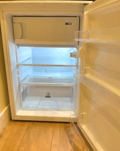 an empty refrigerator with its door open in a kitchen at Central London Chinatown 1 bedroom 1 bathroom Flat in London