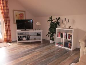 a living room with a flat screen tv on a wooden floor at Ferienwohnung Schwienautal in Hanstedt