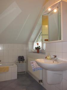 a white bathroom with a sink and a mirror at Ferienwohnung Schwienautal in Hanstedt