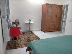 a bedroom with a bed and a chair and a cabinet at TN's House in Da Nang