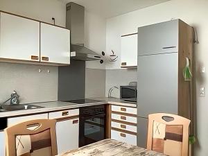 Ferienwohnung Tor zur Natur في مونشبرغ: مطبخ مع خزائن بيضاء وطاولة وكراسي +6 صور