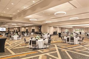 un salón de banquetes con mesas y sillas blancas en Hilton Knoxville Airport en Alcoa