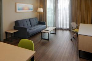 a living room with a couch and a table at City Express Suites by Marriott Tijuana Rio in Tijuana