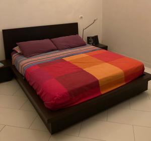 uma cama com uma colcha colorida em Romantic Chic Loä em Loano