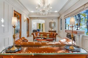 a living room with leather furniture and a chandelier at SaffronStays Naiintara in Nainital
