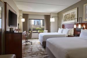 a hotel room with two beds and a desk at Hilton Denver City Center in Denver