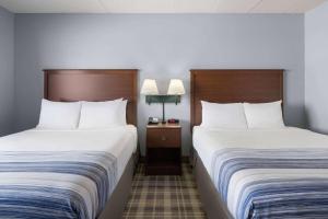 Dos camas en una habitación de hotel contigua en AmericInn by Wyndham Stuart, en Stuart