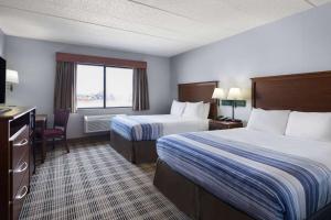 a hotel room with two beds and a window at AmericInn by Wyndham Stuart in Stuart