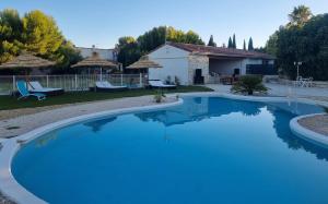 Cazouls-lès-Béziers的住宿－Chambres d'hotes Béziers La Noria，庭院里的一个蓝色海水大型游泳池