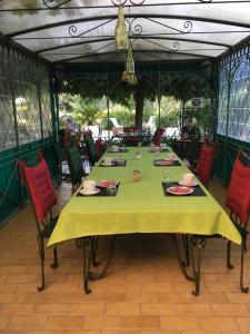 una mesa con mantel amarillo y sillas rojas en Chambres d'hotes Béziers La Noria en Cazouls-lès-Béziers