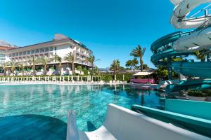 einen Pool in einem Resort mit Rutsche in der Unterkunft DoubleTree by Hilton Antalya-Kemer All-Inclusive Resort in Kemer