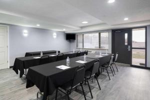una sala conferenze con tavoli e sedie con tovaglia nera di AmericInn by Wyndham Stuart a Stuart Altre 39 foto