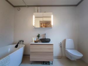 łazienka z umywalką, wanną i toaletą w obiekcie Villaidyll i Svanesund nära havet w mieście Svanesund