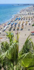 una playa con muchas sombrillas y gente en ella en Semi-detached Adosado con Encanto -130 m2 - WiFi 600 Mb - Piscina Comunitaria - Patio Privado, en Torremolinos