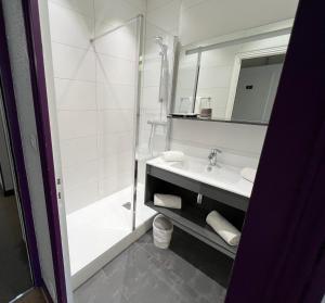 een witte badkamer met een douche en een wastafel bij Le Relais de la Sans Fond in Fénay