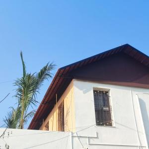 un edificio con una palmera en el fondo en Maha Periyava Kuteeram en Kumbakonam