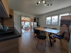 a kitchen and dining room with a table and chairs at Entre lac et montagne, côté calme, spacieux 3 pièces avec grand jardin in Saint-Jorioz +20 photos