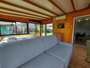 ein großes weißes Sofa in einem Zimmer mit Fenstern in der Unterkunft Entre lac et montagne, côté calme, spacieux 3 pièces avec grand jardin in Saint-Jorioz