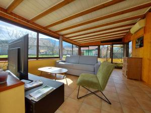 sala de estar con sofá y TV en Entre lac et montagne, côté calme, spacieux 3 pièces avec grand jardin, en Saint-Jorioz
