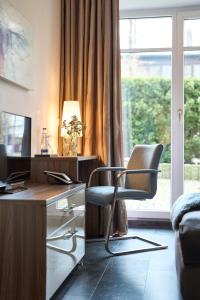 a desk and a chair in a room with a window at Hotel am Hof in Taufkirchen