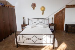 - une chambre avec un lit en métal et des draps blancs dans l'établissement Nick and Bill's Family House Leros, à Vromolithos