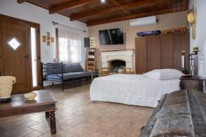 - une chambre avec un lit et un salon avec une cheminée dans l'établissement Nick and Bill's Family House Leros, à Vromolithos