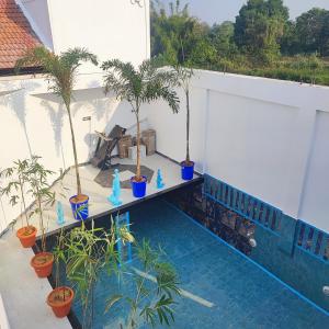 un balcón con palmeras y una piscina en Maha Periyava Kuteeram en Kumbakonam