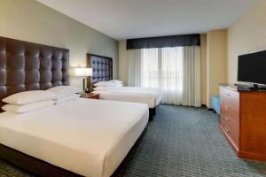 a hotel room with two beds and a flat screen tv at Drury Inn & Suites Phoenix Chandler Fashion Center in Chandler