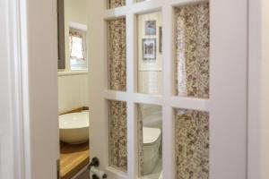 een badkamer met een toilet, een wastafel en een spiegel bij Keramidogatos Manos Guest House, Corfu Old Town in Corfu-stad