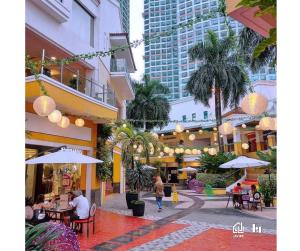 a shopping mall with people sitting at tables and umbrellas at Casa de Lorille Eastwood Cozy Studio with Amazing view Free WiFi & Netflix Access in Manila