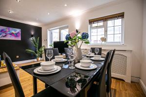 a dining room with a black table and chairs at Milton Keynes for Families and Contractors with Private Parking in Shenley Brook End