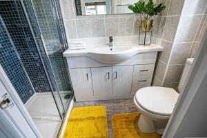 a bathroom with a toilet and a sink and a shower at Milton Keynes for Families and Contractors with Private Parking in Milton Keynes +30 photos