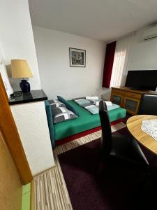 um quarto com uma cama verde e uma mesa em Guest House Nana em Mostar