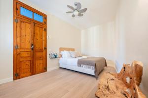 Schlafzimmer mit einem Bett und einem Deckenventilator in der Unterkunft Sweet Inn - Wellington in Barcelona
