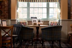 um restaurante com uma mesa e cadeiras e uma janela em The Kingslodge Inn - The Inn Collection Group em Durham