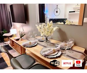 a dining room table with plates and wine glasses at Casa de Lorille Eastwood Cozy Studio with Amazing view Free WiFi & Netflix Access in Manila