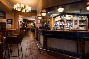 a bar in a restaurant with a counter and chairs at The Kingslodge Inn - The Inn Collection Group in Durham