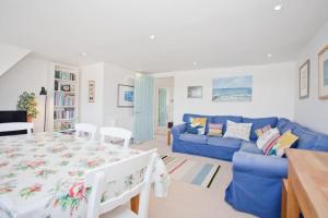 ein Wohnzimmer mit einem blauen Sofa und einem Tisch in der Unterkunft Bournecoast: Spacious apartment with WIFI - FM9589 in Bournemouth