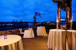 a group of tables with white table cloths on a patio at The Westin Waltham Boston in Waltham