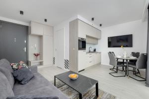 a living room with a couch and a table at Modern Apartment with Balcony and Parking by Noclegi Renters in Mielno +13 photos