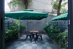 een tafel en stoelen onder een grote groene parasol bij Atour Light (Chengdu Jinli) in Chengdu