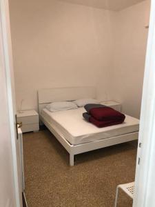 a white bed with a red blanket on it at La Casetta Gialla in Genoa